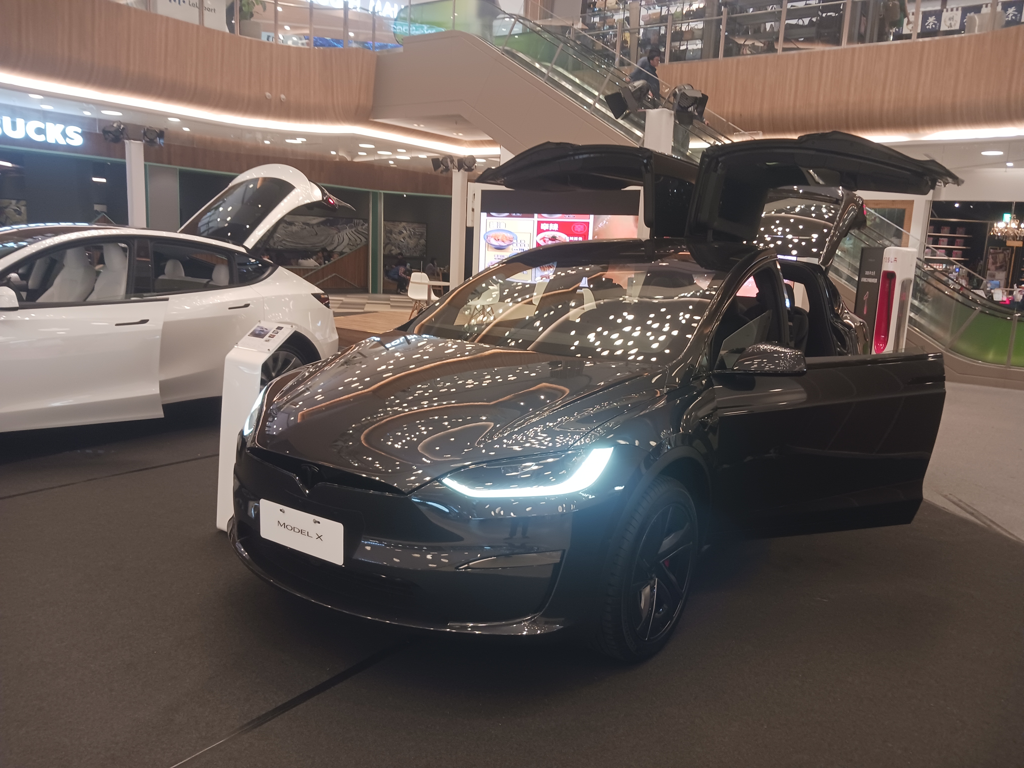 Tesla Model X Elektro-SUV mit geöffneten Falcon-Wing-Türen im Showroom